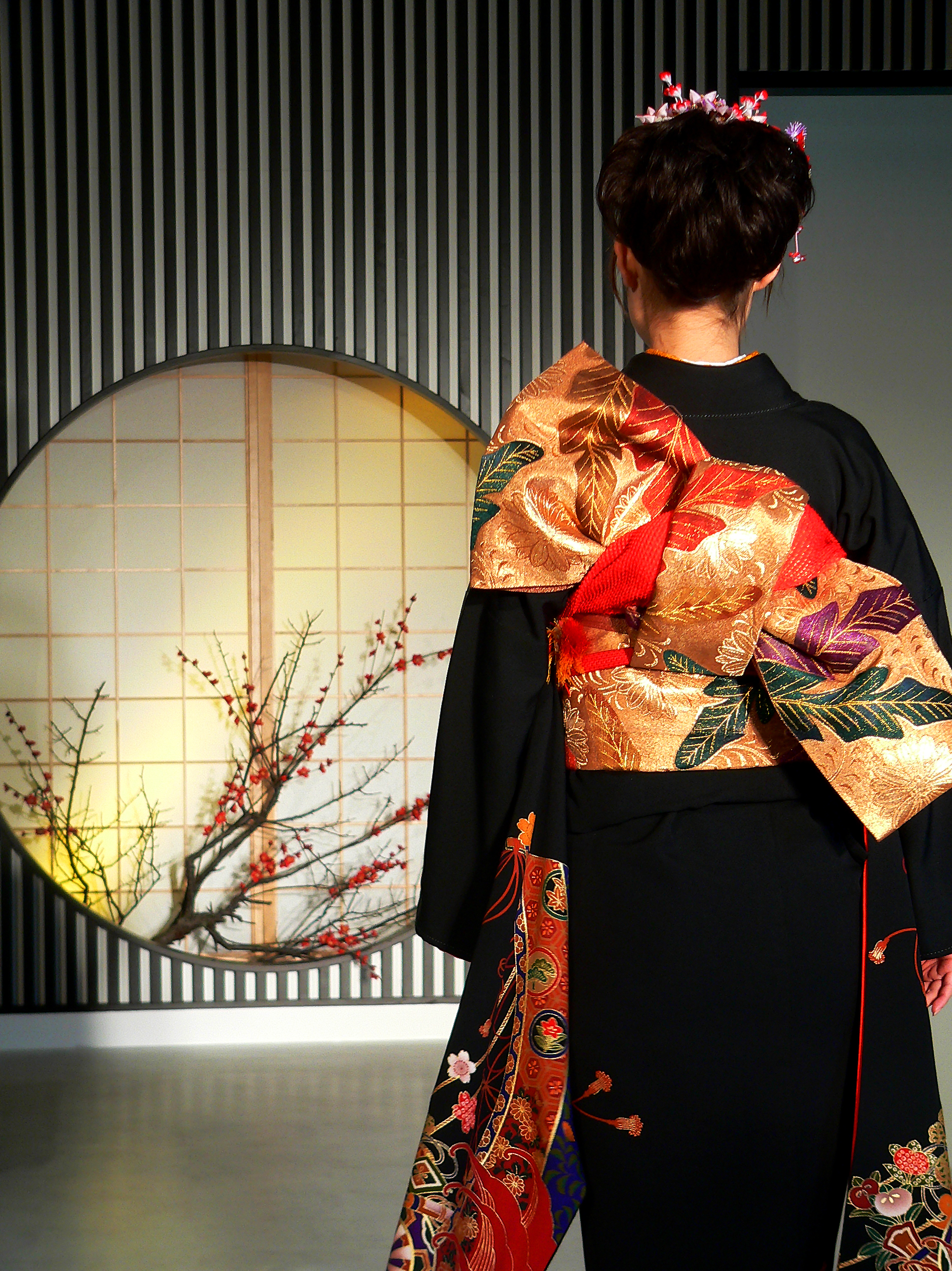 Hermosa vista posterior de un kimono adecuadamente vestido que muestra una intrincada técnica de atado de obi y un elegante drapeado de tela de seda.