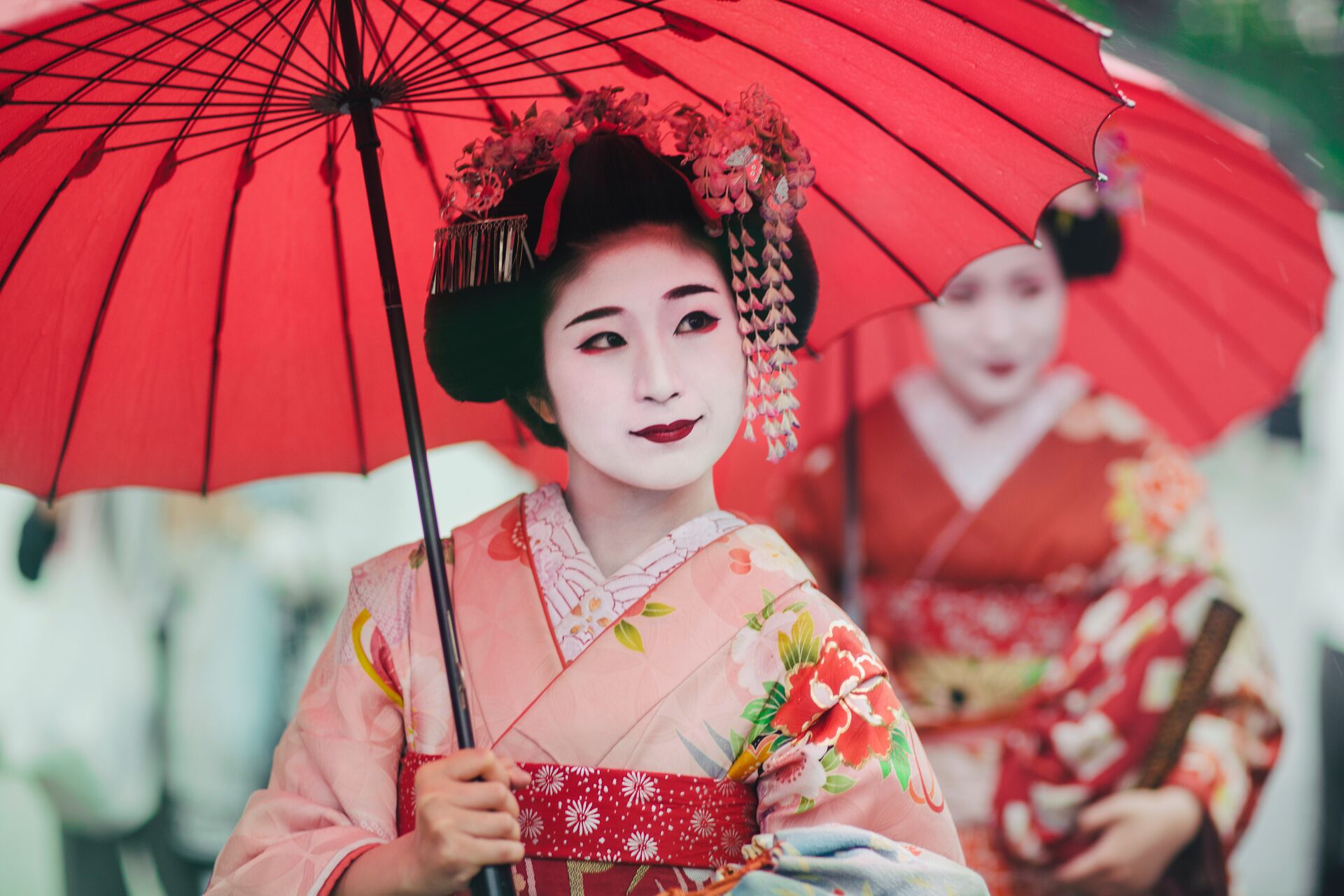 Un grupo de mujeres japonesas con elegantes kimonos y peinados tradicionales caminan por las calles históricas de Kioto, demostrando la belleza japonesa atemporal y la elegancia cultural.