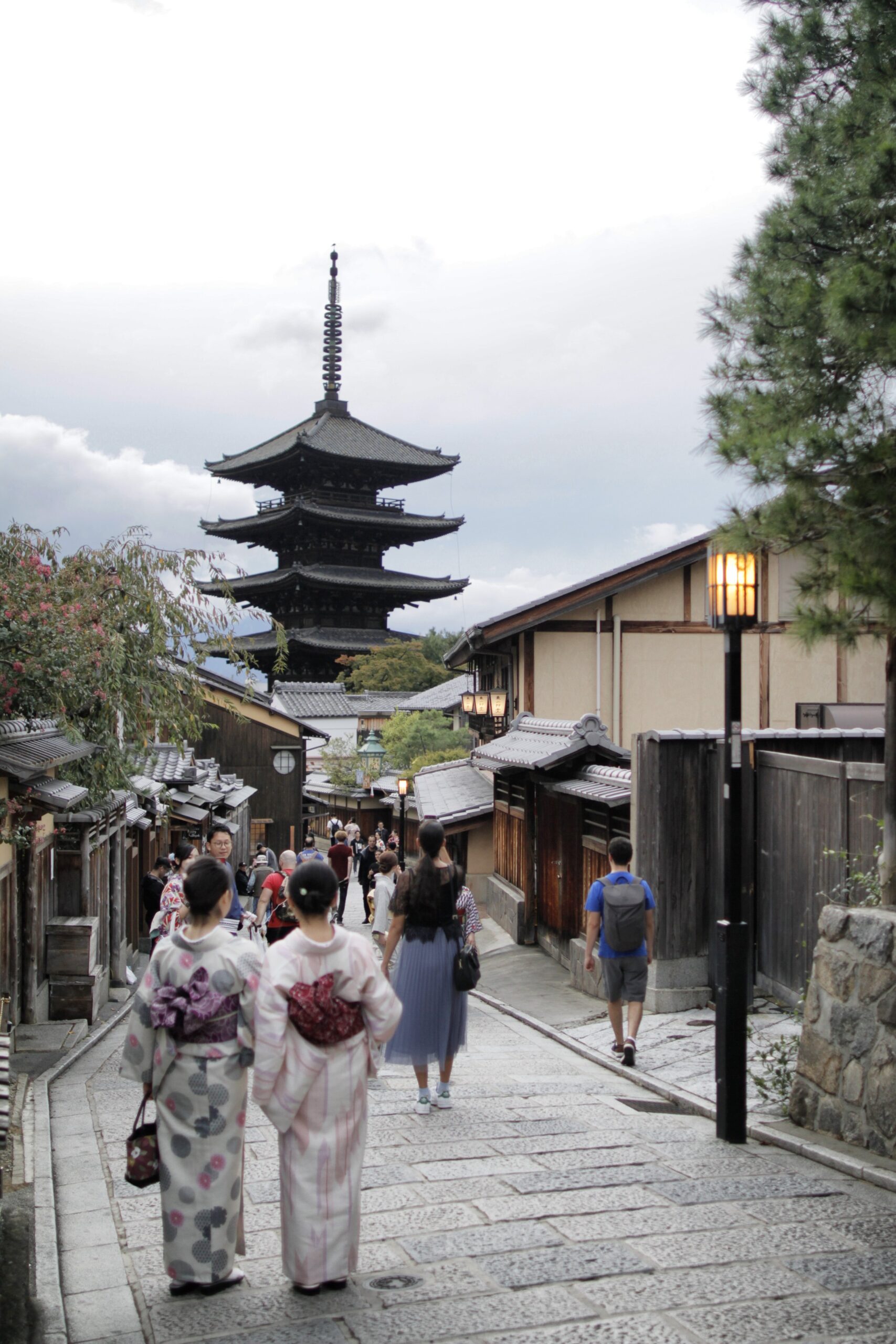 Mujer con un elegante kimono explorando serenos jardines de un templo en Kioto con arquitectura tradicional y atmósfera tranquila.