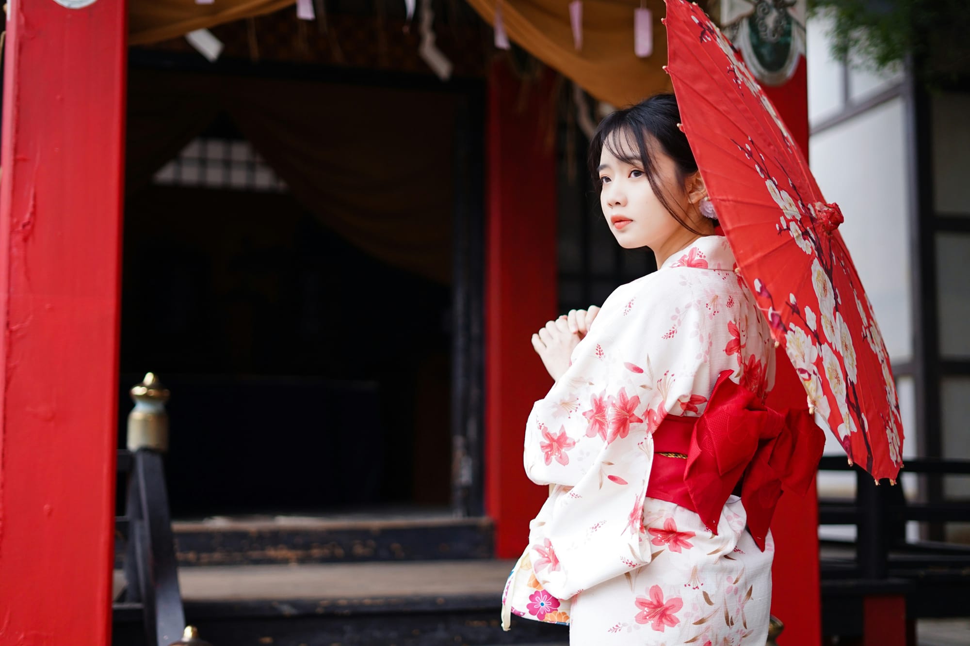 Una mujer con un kimono tradicional camina por una calle histórica de Kioto con arquitectura tradicional japonesa.