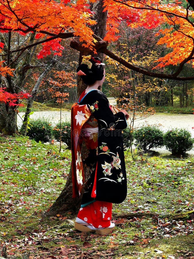 Una mujer con un elegante kimono disfruta de las hojas de arce otoñales en Kioto, Japón, creando conexiones emocionales a través de la inmersión cultural.