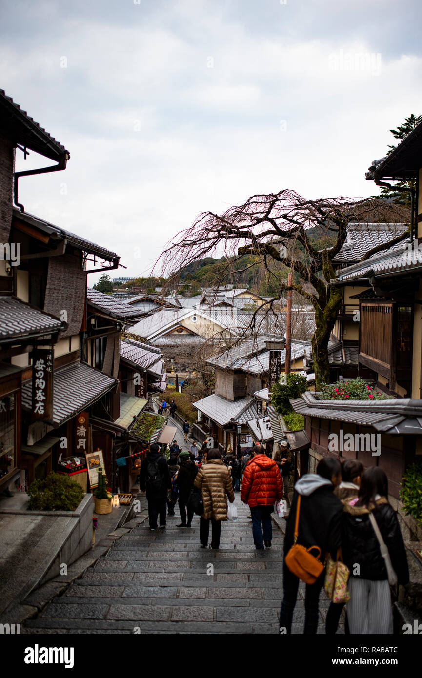 Turistas y mujeres japonesas con kimonos tradicionales caminan juntos hacia el histórico templo Kiyomizu-dera en Kioto, mostrando una auténtica participación cultural.
